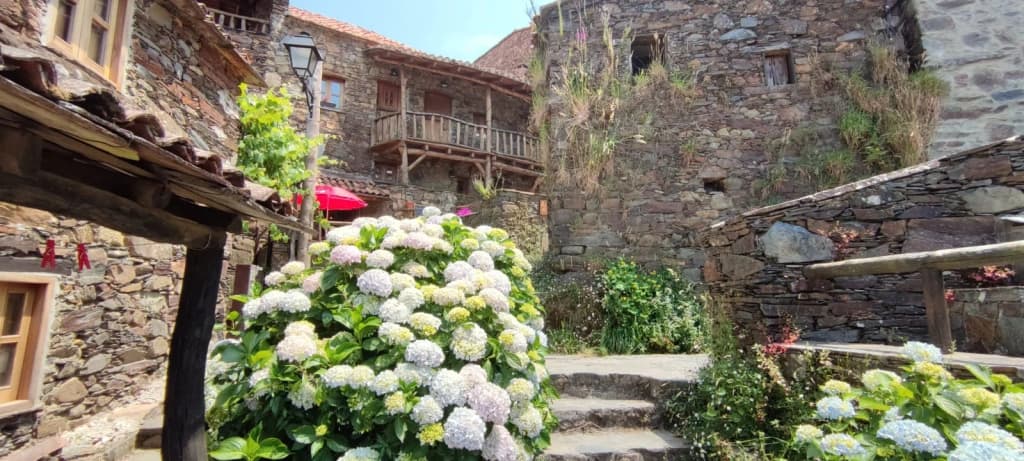 Casas de pedra da aldeia de Talasnal com montanhas ao fundo
