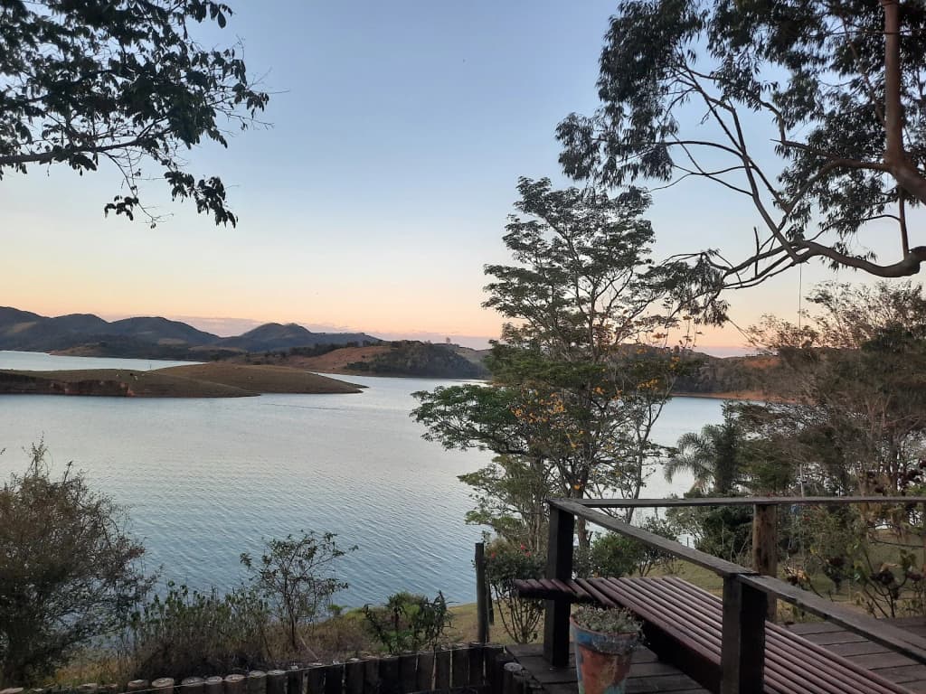 Interior do chalé: madeira, janelas grandes, decoração aconchegante, vista para o lago