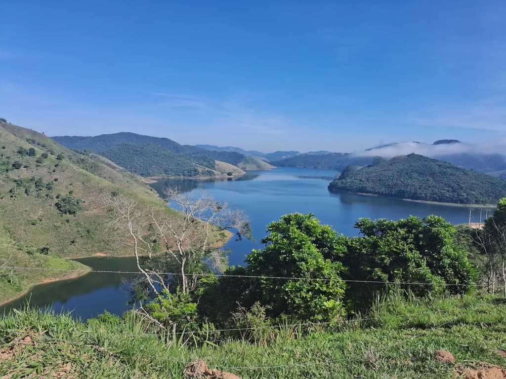 Porto da Canoa: píer da balsa, água calma, morros cobertos de mata