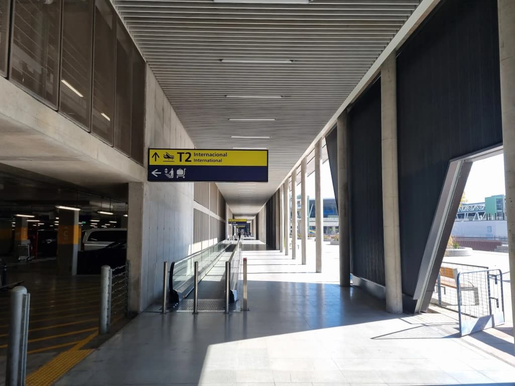Saguão de desembarque no Aeroporto de Santiago, viajantes com malas