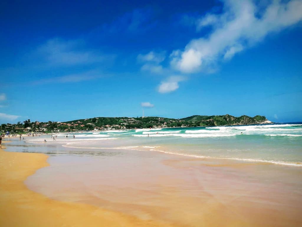 Playa de Geribá con agua esmeralda y surfistas
